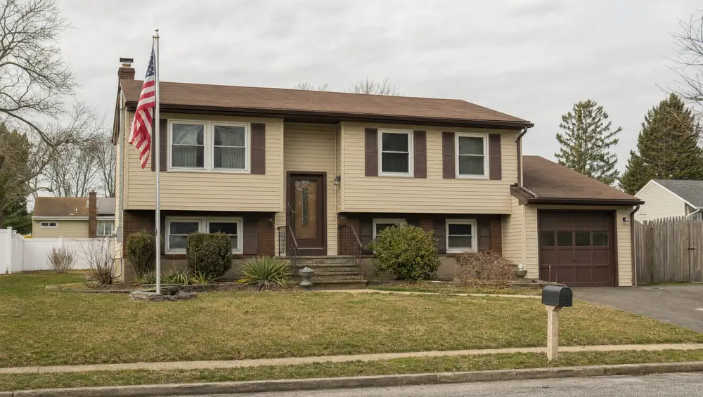Couple reviewing house documents at a table, weighing a buyout vs selling outright during a New Jersey divorce