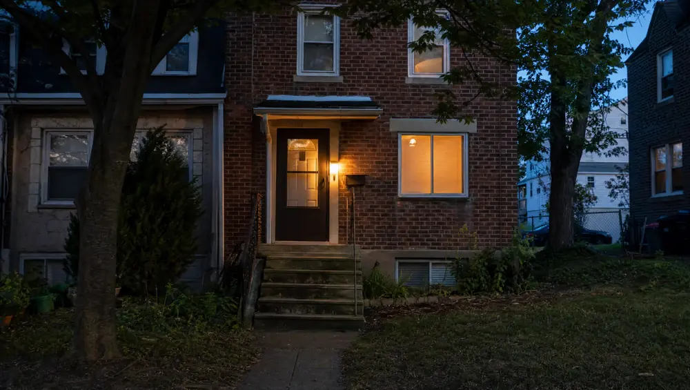 Couple reviewing divorce paperwork beside a New Jersey home. Deciding whether to sell before or after the settlement